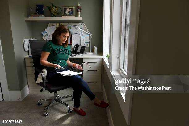 Sue-Ann Siegel goes over notes after taking a call from a man experiencing anxiety about the coronavirus as she monitors the Montgomery County...