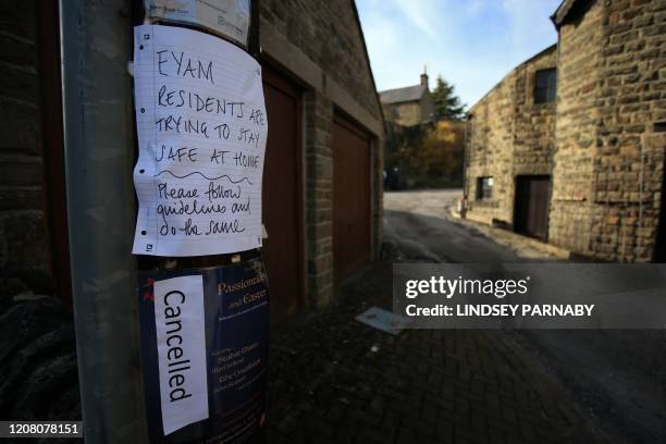 Sign on a lamp post asking people to stay at home and observe the guidelines on social distancing is seen in the village of Eyam in Derbyshire,...