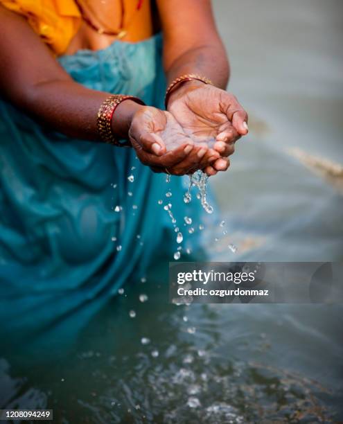 oude vrouw die water van heilige rivier ganges giet, sluit omhoog mening - ganges stockfoto's en -beelden