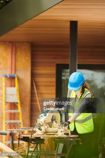 female joiner cutting cladding - safety glasses at home stock pictures, royalty-free photos & images