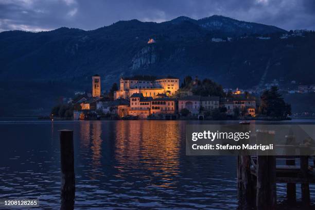 orta san giulio at sunset, with artificial lighting and romantic atmosphere at the lake at night. orta island in piedmont italy - lake orta stock pictures, royalty-free photos & images