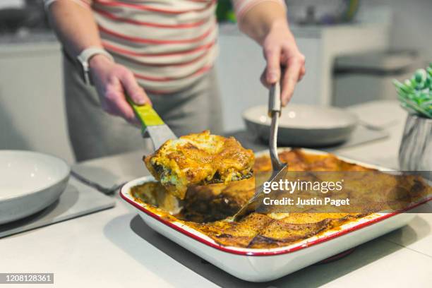 woman serving lasagne - serving lasagna stock pictures, royalty-free photos & images