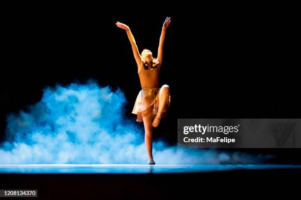 young girl dancing ballet on a dark stage with blue smoke - performing arts event stock pictures, royalty-free photos & images