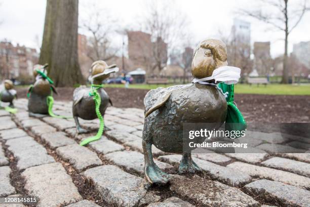 The Make Way For Ducklings statue, dressed up in St. Patrick's Day gear and protective face masks, stand at the Boston Public Garden in Boston,...