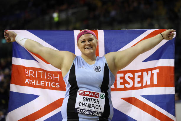 Amelia Strickler of Great Britain poses with a flag after winning the Women's Shot Put during SPAR British Athletics Indoor Championships at Emirates...