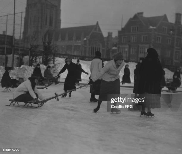 Female students skating and tobogganing on a frozen pond at Barnard College, Manhattan, New York City, circa 1920.