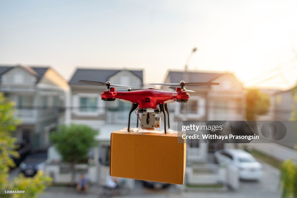 On 23 February 2020, Bangkok, Thailand Delivery drone carrying urgent shipment box in a city.