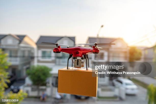 on 23 february 2020, bangkok, thailand delivery drone carrying urgent shipment box in a city. - drone parcel stock pictures, royalty-free photos & images