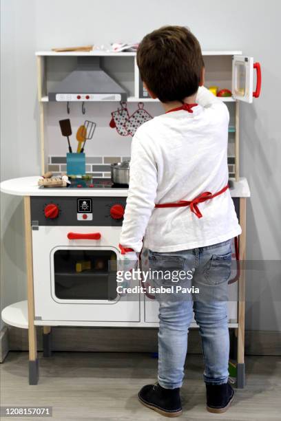 little boy playing with toy kitchen at home - boy cooking stock pictures, royalty-free photos & images