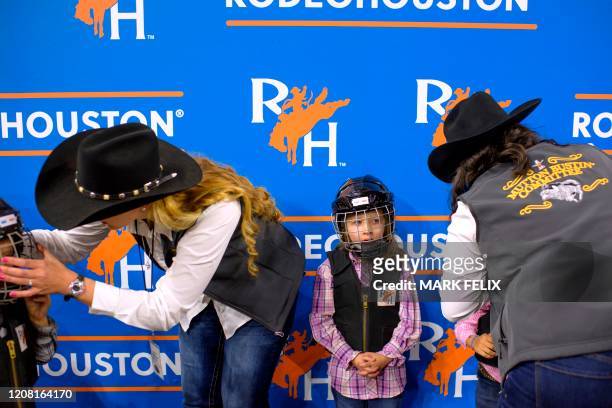 Mutton Bustin' participant Sydney Shields waits in line after having her helmet put on during the Houston Livestock Show and Rodeo on March 6, 2020...