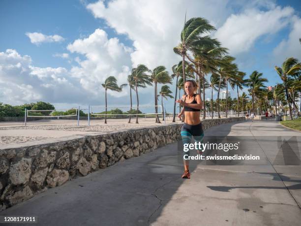 sportive young woman jogging outdoors, miami beach - ocean drive stock pictures, royalty-free photos & images