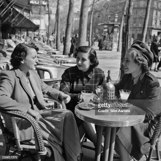 Three women on the cafe terrace of the Hotel De Paris cafe, circa 1949. The cafe is a former Red Cross Rainbow Corner bar used by American servicemen...