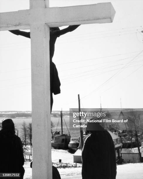 The harbor of Saint-Laurent-de-l'Ile-d'Orleans with a statue of Jesus Christ on the cross in the foreground, Quebec, Canada, 1959. Photo taken during...