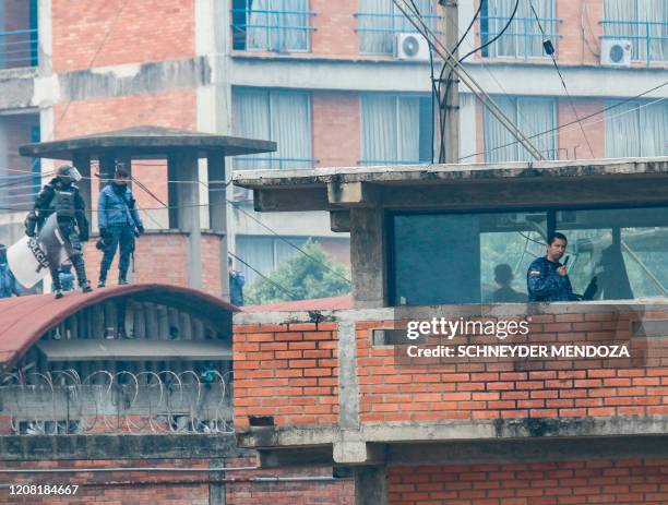 Riot police stand guard inside the Modelo prison in Cucuta during a riot on March 24, 2020.