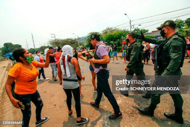 Relatives of inmates argue with police officers outside the Modelo prison in Cucuta during a riot on March 24, 2020.