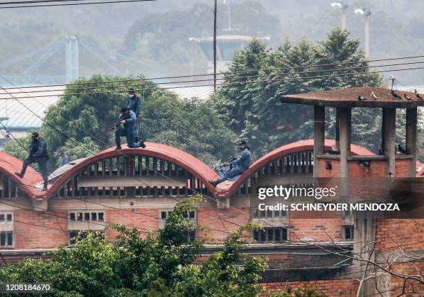 Riot police stand guard inside the Modelo prison in Cucuta during a riot on March 24, 2020.