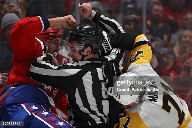 Linesman James Tobias breaks up Evgeni Malkin of the Pittsburgh Penguins and Brenden Dillon of the Washington Capitals during the first period at...