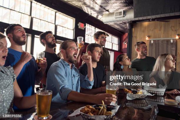 group of friends watching game in bar - cafe counter stockfoto's en -beelden