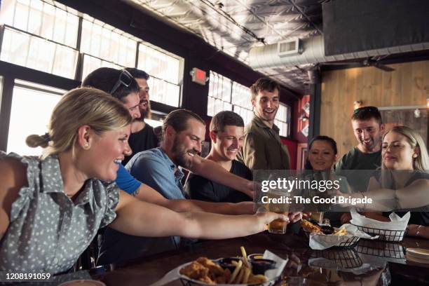 friends toasting beer in pub - bar wide angle stock pictures, royalty-free photos & images