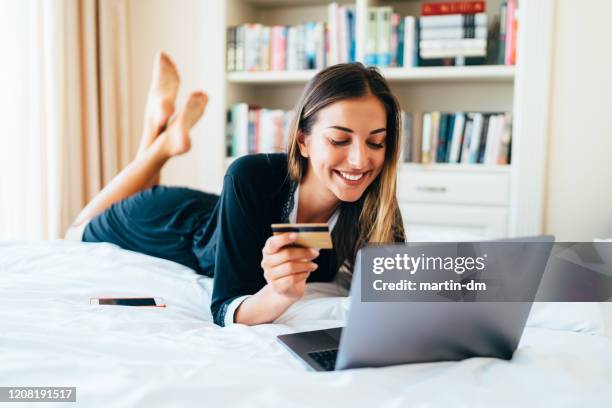 donna a letto a fare shopping online - booking hotel foto e immagini stock
