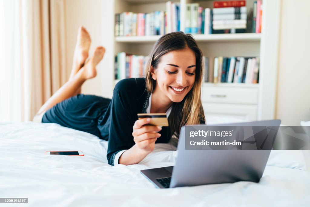 Woman in bed shopping online