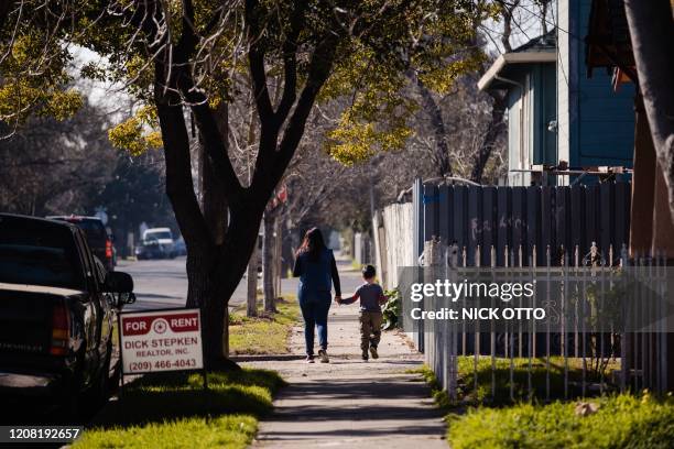 Mother and son walk through one of the neighborhoods of Stockton where participants in the city's universal basic income program live in Stockton,...