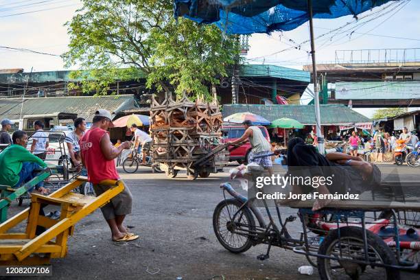 Porters and rickshaw riders resting while waiting for clients in the streets of the Carbon public market.