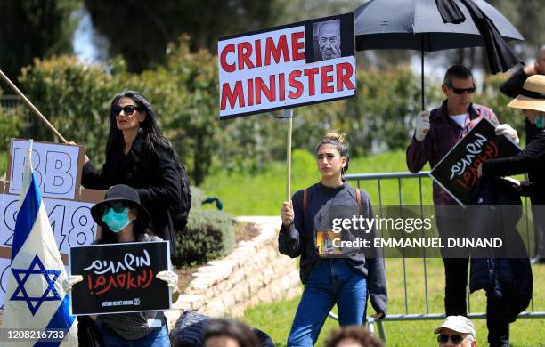 Anti-incumbent government protesters hold placards during a demonstration in front of the Knesset celebrating the resignation of the Knesset Speaker...