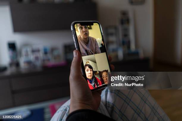 Young woman makes a video call to several friends with her smartphone from her home during the mandatory quarantine decreed by the government as a...
