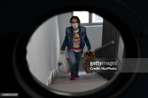 Girl with a mask returns home after buying food during the mandatory government-ordered quarantine of the coronavirus in Santander