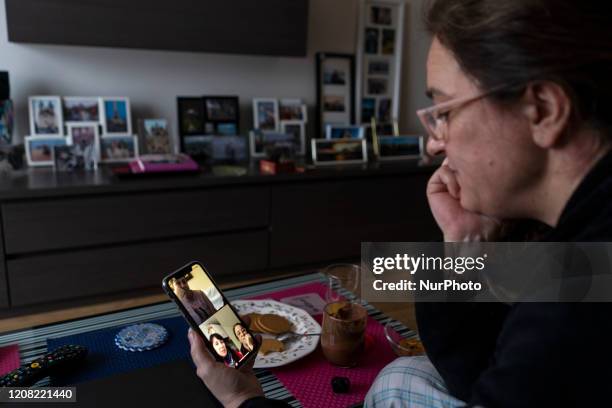 Young woman makes a video call to her friends with her smartphone from her home during the mandatory quarantine decreed by the government as a result...