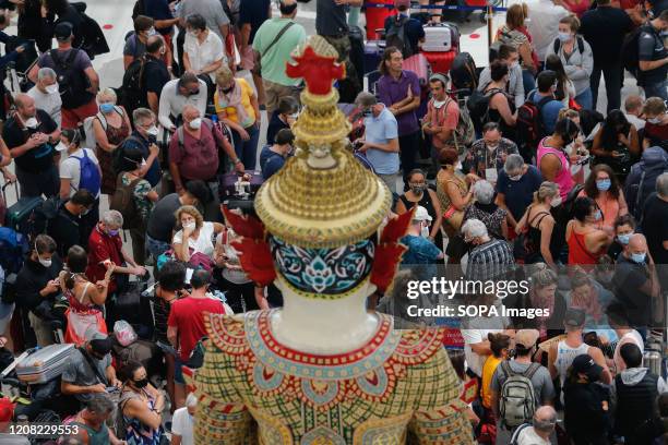 Tourists wait to checks in at the departures hall at Bangkok's Suvarnabhumi Airport.