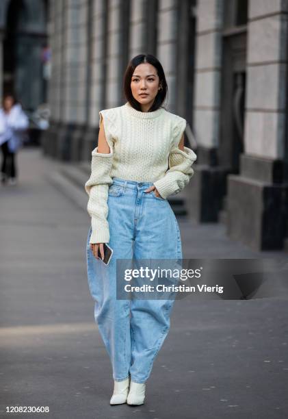 Yoyo Cao is seen wearing denim wide leg jeans, ripped jumper outside Philosophy during Milan Fashion Week Fall/Winter 2020-2021 on February 22, 2020...