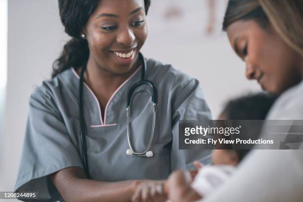 nurse checking baby in wellness medical exam - black newborn stock pictures, royalty-free photos & images