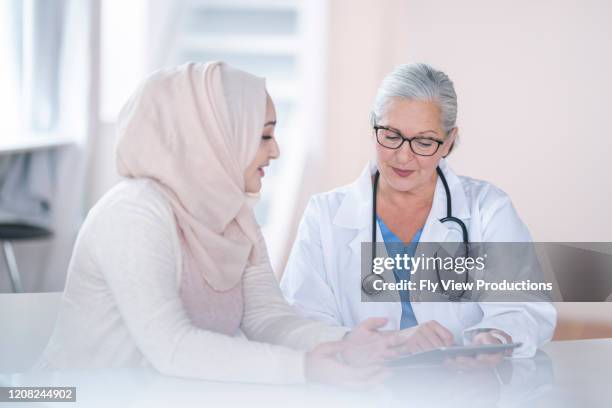 mujer doctora consulta mujer musulmana - hiyab fotografías e imágenes de stock