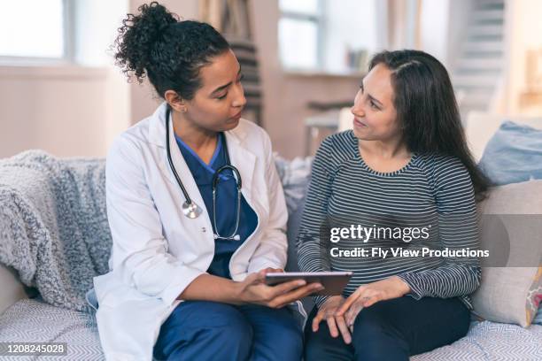 doctor meeting with pregnant woman - clinic canada diversity imagens e fotografias de stock