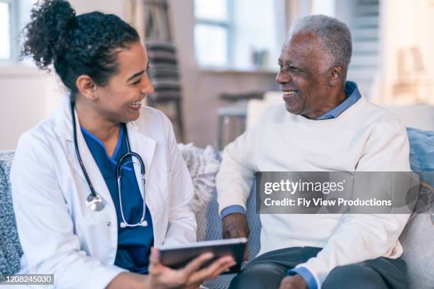 vrouwelijke artsenvergadering met hogere patiënt in zijn huis - medicaid stockfoto's en -beelden