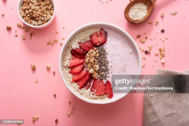 a bowl of healthy and delicious strawberry smoothie with grains and fresh fruit. - smoothie bowl fotografías e imágenes de stock