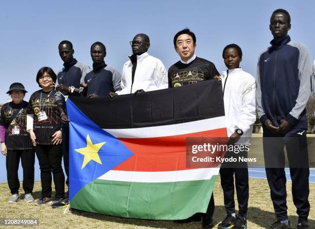 Maebashi Mayor Ryu Yamamoto and five South Sudanese athletes pose for a photo on March 26 with the country's national flag in the eastern Japan city...