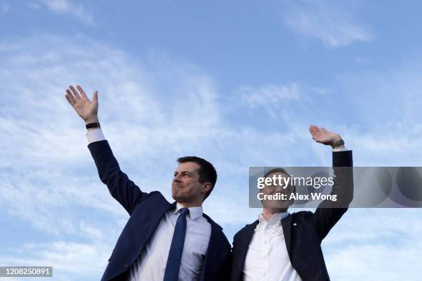 Democratic presidential candidate former South Bend, Indiana Mayor Pete Buttigieg and his husband Chasten Buttigieg wave during a campaign town hall...