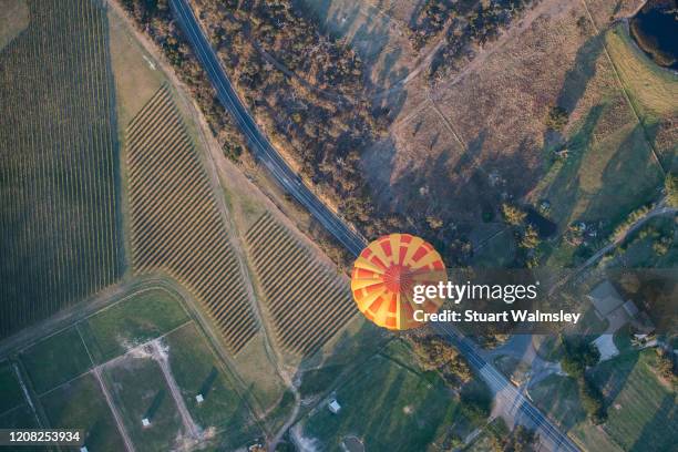 hot air balloon over road - hot air balloon australia stockfoto's en -beelden