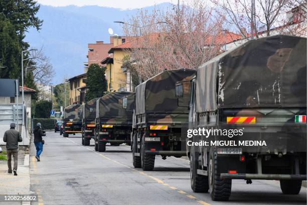 Italian Army trucks transporting coffins of victims of coronavirus cross the city of Bergamo, Lombardy, after leaving the Monumental Cemetery on...