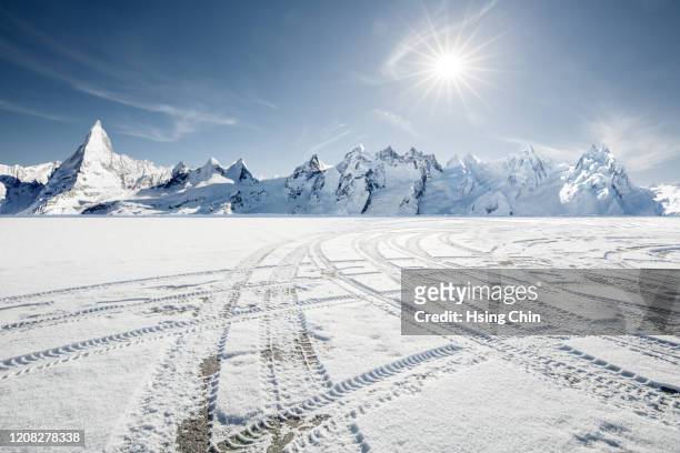 snow mountain road in switzerland - snow covered road stock-fotos und bilder