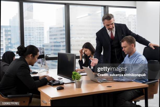 frustrated manager is angry at his colleagues during a meeting in the office. - chef schreit stock-fotos und bilder