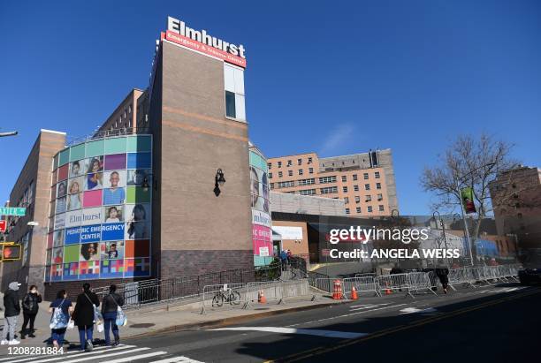 People stand in line to get tested for the coronavirus at Elmhurst Hospital Center in the Queens borough of New York City on March 26, 2020. -...