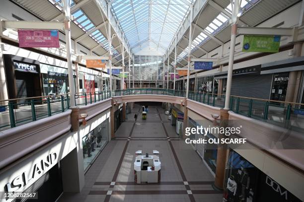 Shops are closed inside the Spindles Town Square Shopping Centre in Oldham, northwest England, on March 26, 2020. - The coronavirus outbreak and...