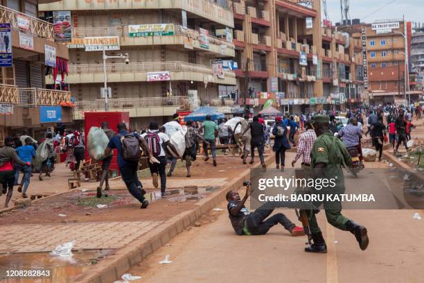 Police officer chases street vendors in Kampala, Uganda, on March 26 after Ugandan President Yoweri Museveni directed the public to stay home for 32...