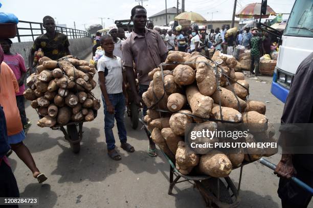 Vendors carry yams in wheelbarrows to sell to buyers in defiance to a seven-day partial shutdown of Lagos announced by the state government to curb...