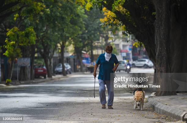 Man walks his dogl, on Day 2 of the three week nationwide lockdown to check the spread of coronavirus, at C R Park on March 26, 2020 in New Delhi,...