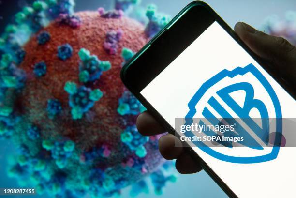 In this photo illustration the American film studio, production and film distributor company Warner Bros logo seen displayed on a smartphone with a...